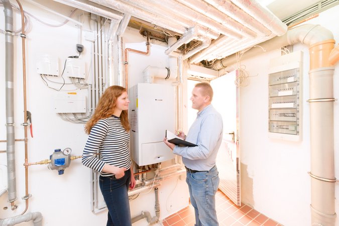 Ein Mann gibt einer Frau eine Kundenberatung in einem weißem Raum mit Wasserpumpen an der Wand