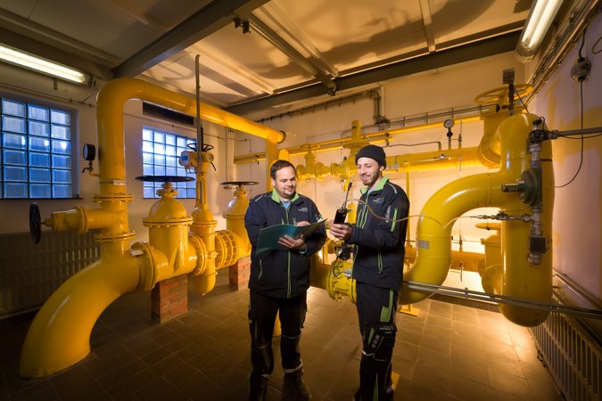 Zwei Stadtwerke-Mitarbeiter stehen in einer Gasübergabestation