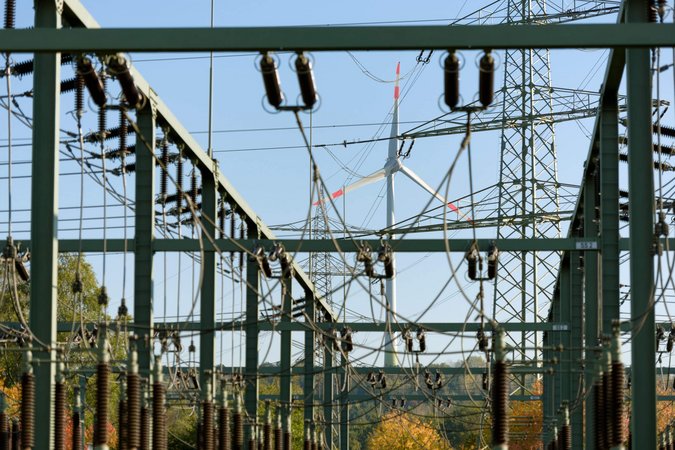 Stromnetz mit Windkraftanlage im Hintergrund