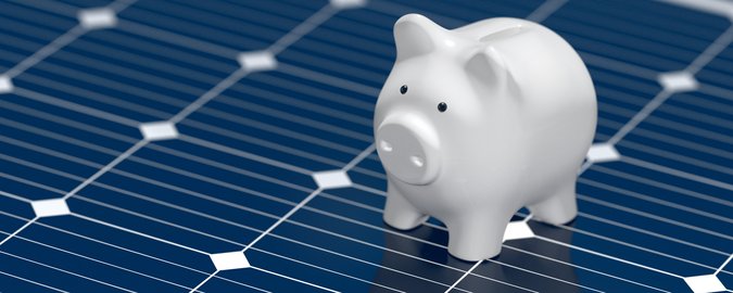 Ein Sparschwein hüpft auf einem Solar Panel herum.