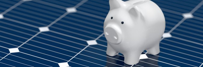 Ein Sparschwein hüpft auf einem Solar Panel herum.