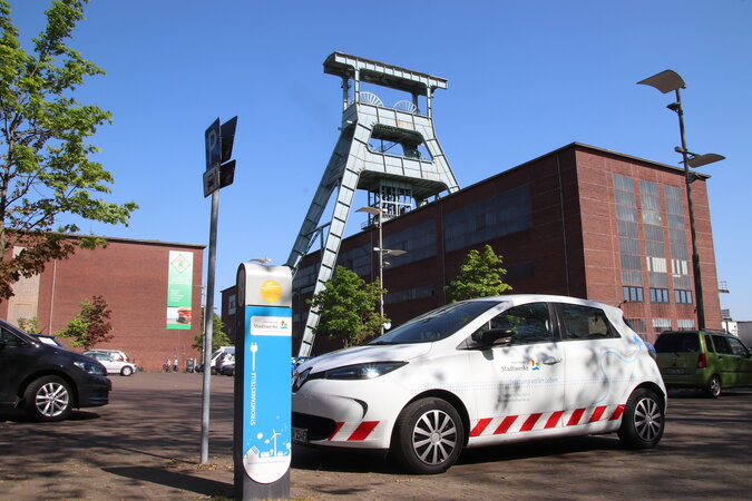 E-Ladesäule an der Zeche in Herten Ein weißes Elektroauto steht an einer Ladestation vor einer Zeche.