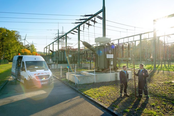 Stadtwerke Mitarbeiter stehen vor Stromleitungen