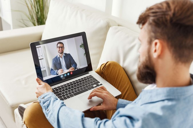 Ein Mann sitzt auf einem Sessel und schaut sich auf seinem Laptop ein Erklärvideo zum Service und Beratung der Stadtwerke Herten an. 