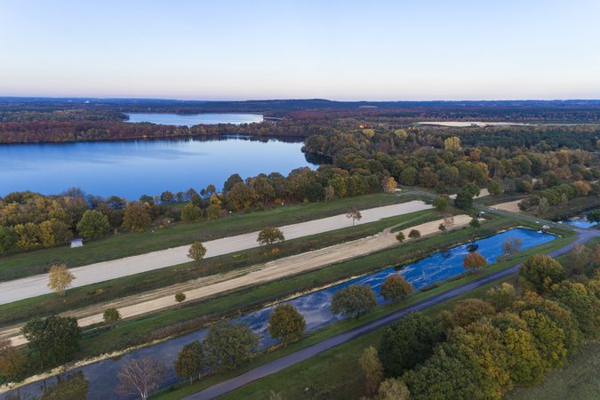 Eine Aufnahme einer Landschaft mit prächtigen Seen. Im Vordergrund drei Wasserstraßen zur Gewinnung von Trinkwasser aus der Vogelperspektive.